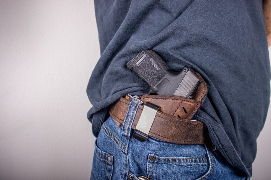 gun belt man So many citizens have guns making it harder to control gun violence. Man with a gun in his belt.