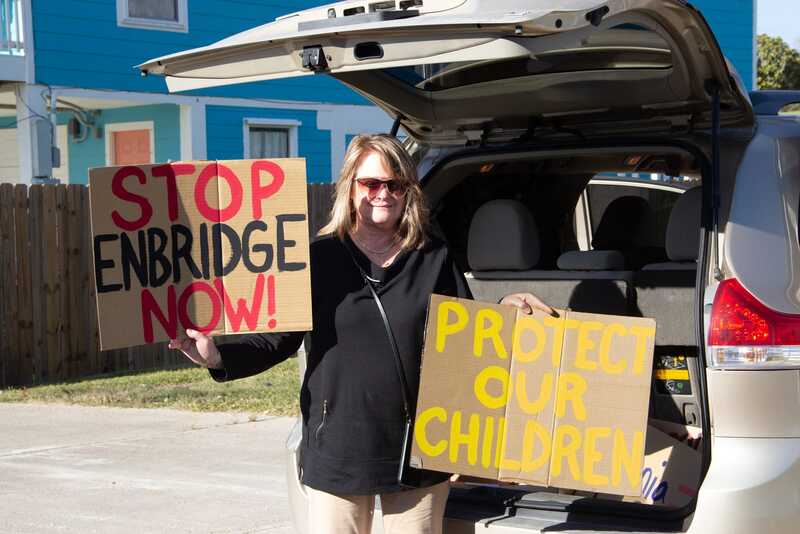 Texas oil protester holding signs