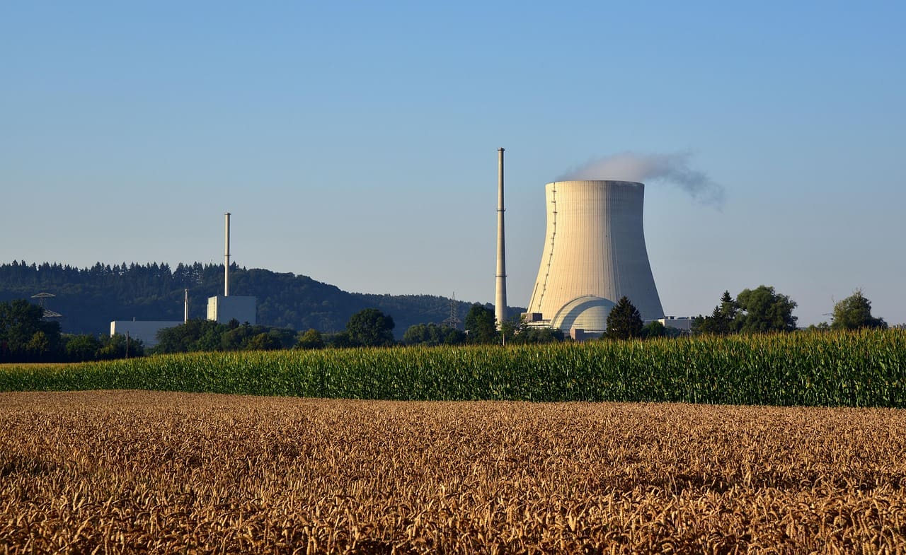 A functional nuclear power plant seen across a field in the country.